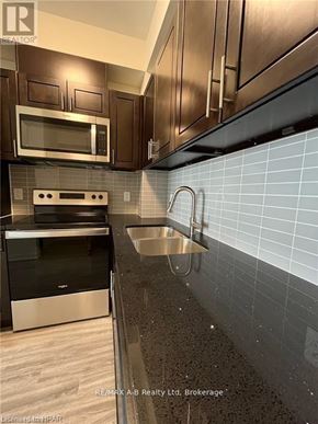 Waterloo condo for rent - A kitchen with a black oven and a black microwave.
