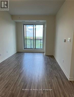 Waterloo condo for rent - A room with wood flooring and a large window.