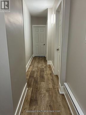 Toronto (Oakwood Village) townhouse for rent - A hallway with wood flooring and white walls.