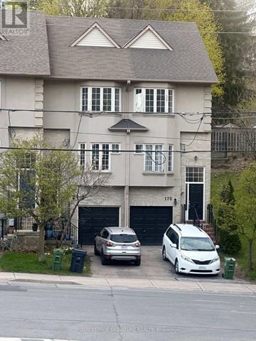 Toronto (Crescent Town) townhouse for rent - A two-story house with a garage and a car parked in front.