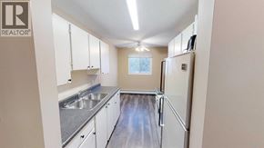 Grande Prairie apartment for rent - A kitchen with white cabinets and a refrigerator.