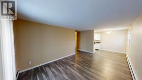 Grande Prairie apartment for rent - A spacious room with wooden flooring and a white ceiling.