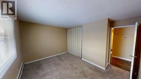 Grande Prairie apartment for rent - A room with a carpeted floor and a door leading to another room.