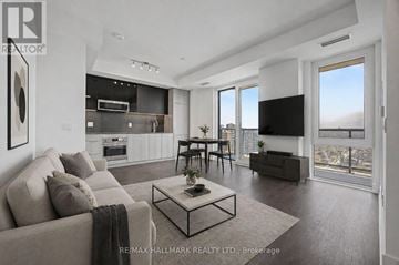 Toronto (Church-Yonge Corridor) condo for rent - A modern living room with a large couch, a coffee table, and a flat-screen TV.