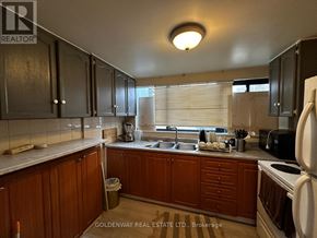 Toronto (Black Creek) townhouse for rent - A kitchen with wooden cabinets and a white fridge.