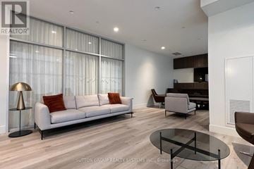 Toronto (Weston-Pellam Park) condo for rent - A modern living room with a white sofa and a glass coffee table.
