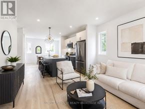 London North (North C) townhouse for rent - A modern living room with a dining area and a kitchen in the background.