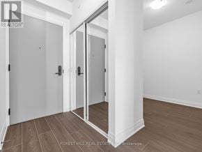Toronto (Bathurst Manor) condo for rent - A room with a white wall and a wooden floor with a glass door.