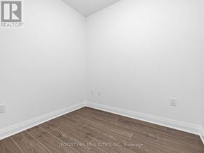 Toronto (Bathurst Manor) condo for rent - A room with wooden flooring and white walls.