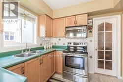 Brampton (Fletcher's Creek Village) apartment for rent - A kitchen with a stove, sink, and cabinets.