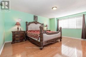 Brampton (Fletcher's Creek Village) apartment for rent - A bedroom with a large bed and a wooden dresser.
