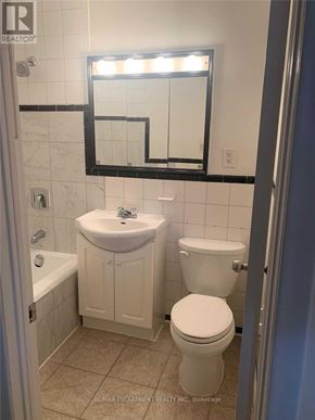 Mississauga (Port Credit) apartment for rent - A white toilet sits next to a sink in a bathroom.