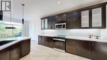 Georgina (Sutton & Jackson's Point) apartment for rent - A modern kitchen with dark brown cabinets and a white countertop.