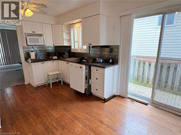 Niagara Falls apartment for rent - A kitchen with white cabinets and a black countertop.