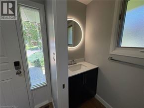 Niagara Falls apartment for rent - A bathroom with a white sink and a round mirror.