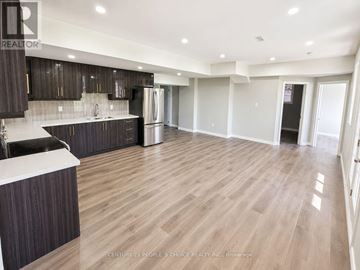 Brampton (Credit Valley) apartment for rent - A spacious kitchen with dark wood cabinets and a white countertop.