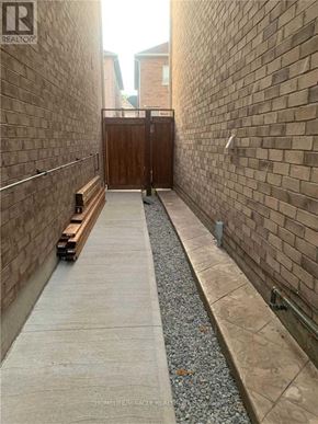Brampton (Northwest Brampton) apartment for rent - A narrow alley with a wooden gate at the end.