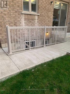 Brampton (Northwest Brampton) apartment for rent - A white metal fence in front of a brick house.