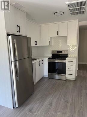 Fort Erie (Ridgeway) condo for rent - A kitchen with a stainless steel refrigerator and a stove top oven.