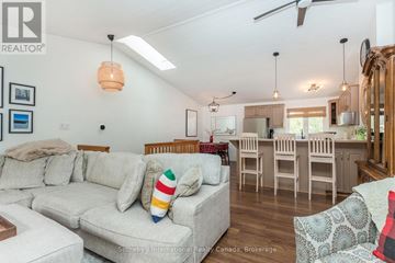 Collingwood townhouse for rent - A living room with a grey sofa and a wooden dining table.