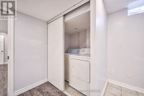 Toronto (Tam O'shanter-Sullivan) apartment for rent - A white washing machine is in a small laundry room.
