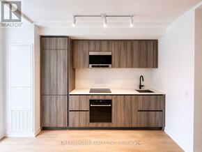 Toronto (Mount Pleasant West) condo for rent - A modern kitchen with wooden cabinets and a stainless steel oven.
