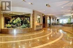 Toronto (Steeles) condo for rent - A reception area with a large plant and a Realty sign.