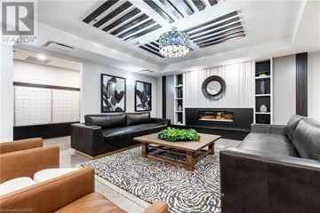 Hamilton (Stoney Creek) condo for rent - A living room with a black couch and a zebra print rug.