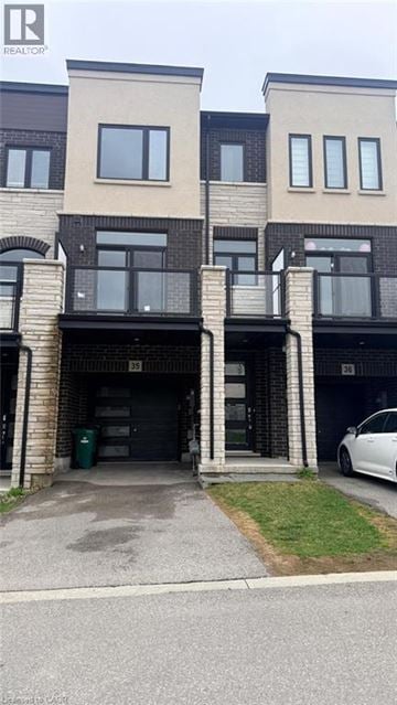 Cambridge townhouse for rent - A white car is parked in front of a building.
