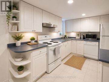 Newmarket (Gorham-College Manor) apartment for rent - A kitchen with white cabinets and a black countertop.