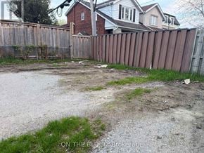 Toronto (Danforth Village-East York) apartment for rent - A backyard with a wooden fence and a dirt area in the middle.