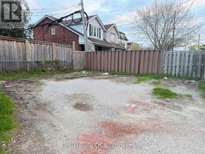 Toronto (Danforth Village-East York) apartment for rent - A backyard with a dirt area and a wooden fence.