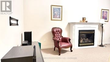 Richmond Hill (Westbrook) apartment for rent - A red leather chair sits in front of a fireplace in a living room.