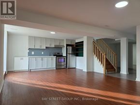 Oshawa (Donevan) apartment for rent - A spacious kitchen with white cabinets and a staircase in the background.