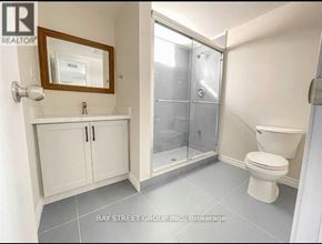 Oshawa (Donevan) apartment for rent - A white bathroom with a toilet, sink, and medicine cabinet.