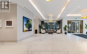 Toronto (South Parkdale) condo for rent - A spacious lobby with a marble floor and a large painting on the wall.