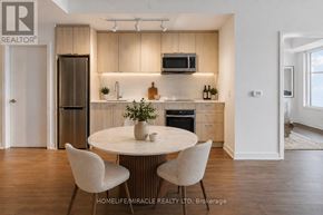 Toronto (South Parkdale) condo for rent - A modern kitchen with a round table and chairs.
