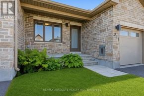 Mississippi Mills townhouse for rent - A house with a stone facade and a garage door.