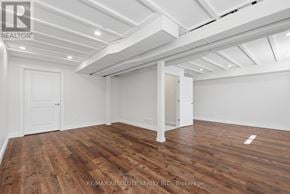 Mississippi Mills townhouse for rent - A room with wooden floors and white walls, with a ceiling that has exposed beams.