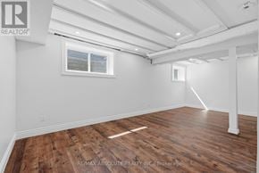 Mississippi Mills townhouse for rent - A room with wooden flooring and white walls, with a window and a door frame visible.
