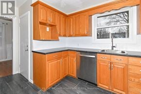 Oshawa (Centennial) apartment for rent - A kitchen with wooden cabinets and a black countertop.