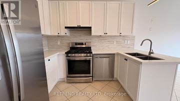 Vaughan (Patterson) apartment for rent - A kitchen with white cabinets and a stainless steel refrigerator.