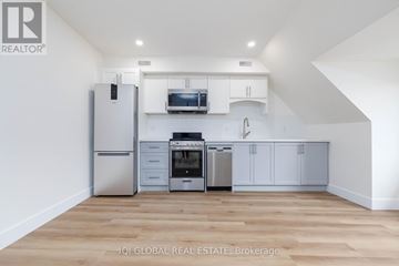 Toronto (Dovercourt-Wallace Emerson-Junction) multi-family for rent - A kitchen with white cabinets and stainless steel appliances.