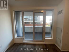 Kitchener condo for rent - A room with a large window and a sliding door.
