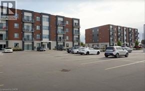 Ayr apartment for rent - A parking lot with cars and apartment buildings in the background.