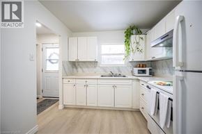 Waterloo townhouse for rent - A white kitchen with a refrigerator, microwave, and oven.
