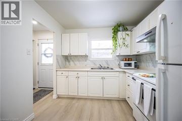 Waterloo townhouse for rent - A white kitchen with a refrigerator, microwave, and oven.