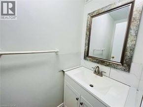 Waterloo townhouse for rent - A bathroom with a sink, mirror and a white tiled wall.