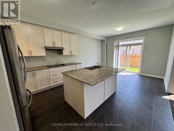 Brampton (Northwest Brampton) apartment for rent - A kitchen with a granite countertop and a refrigerator.
