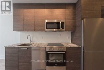 Toronto (Church-Yonge Corridor) condo for rent - A modern kitchen with a stainless steel refrigerator and a microwave above the counter.